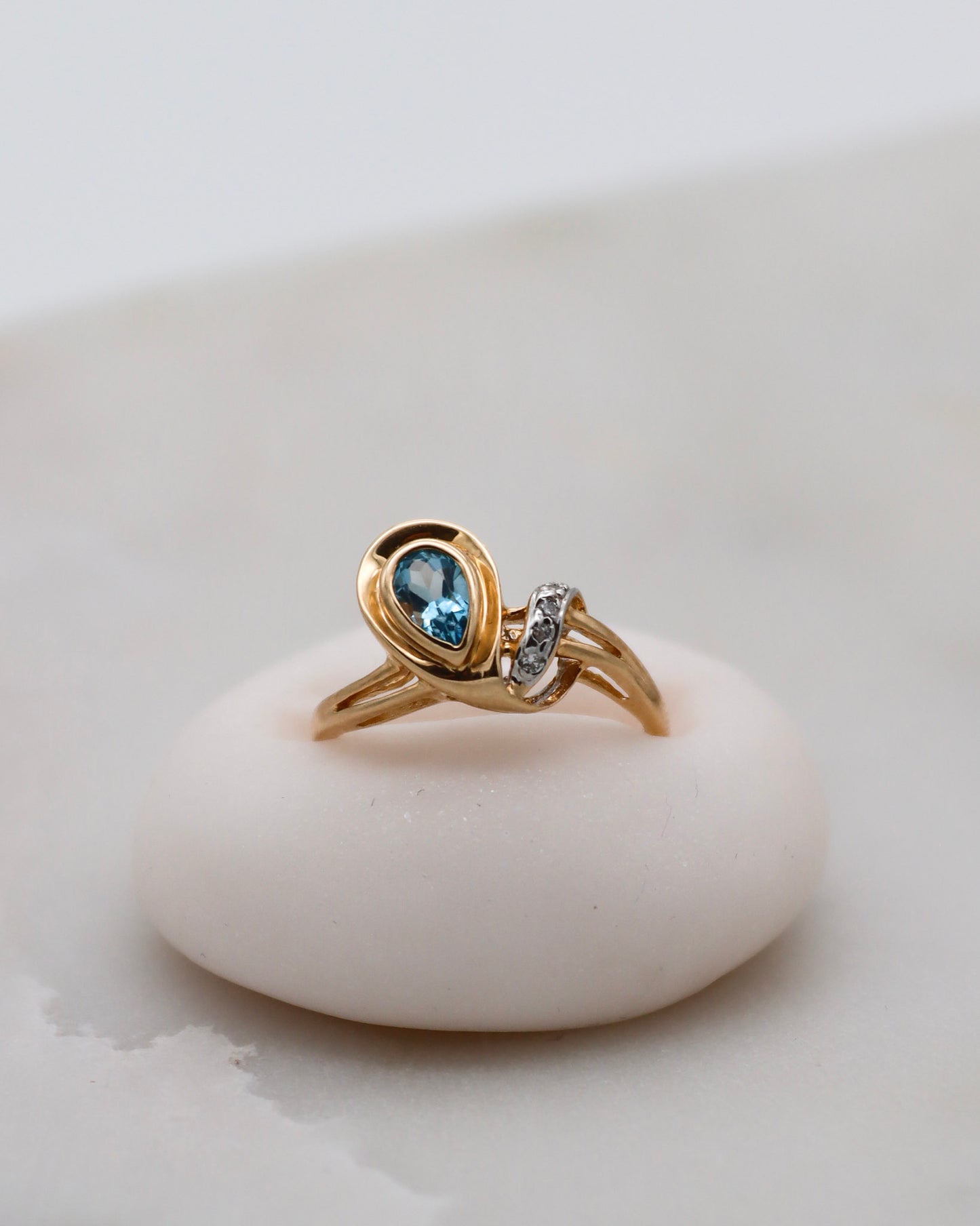 Eleganter Vintage-Ring Aretha mit birnenförmigem blauem Topas (0.20ct) und vier funkelnden Diamanten (0.03ct) in 585 Gelbgold. Erhältlich in München & Augsburg.