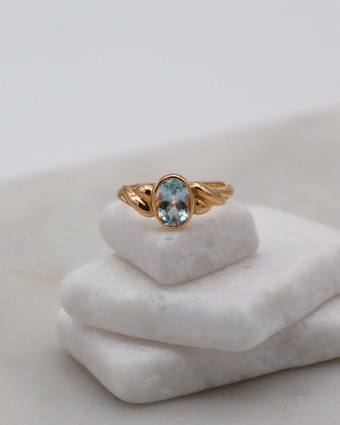 Vintage-Ring Nina mit 0.39ct ovalem Aquamarin und kunstvollem Flechtmuster in 585 Gelbgold. Verfügbar in München & Augsburg.