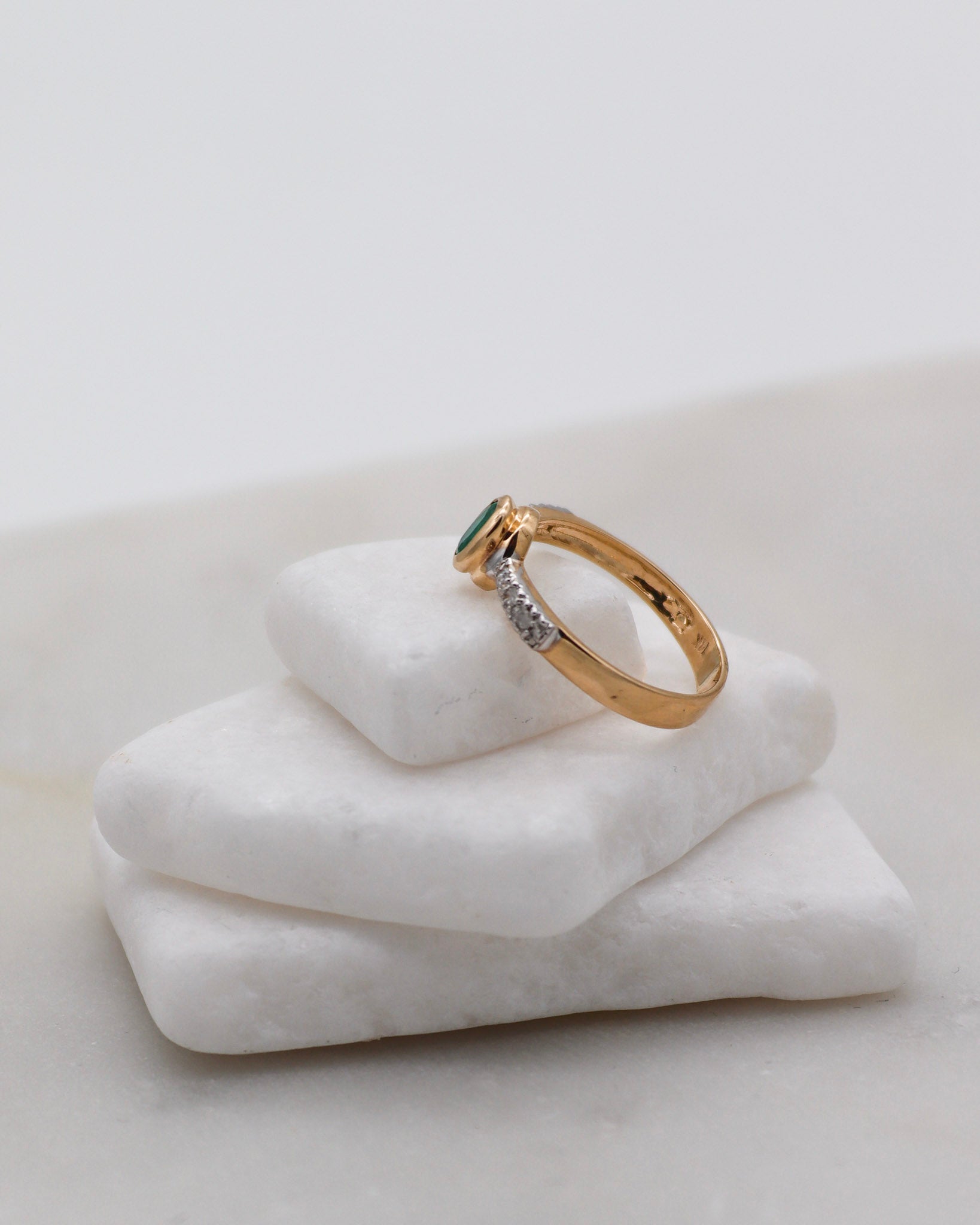 Vintage-Ring Nancy mit ovalem Smaragd (0.21ct), umgeben von Diamanten (ca. 0.06ct) in 585er Gelbgold und Weißgold, erhältlich in München und Augsburg