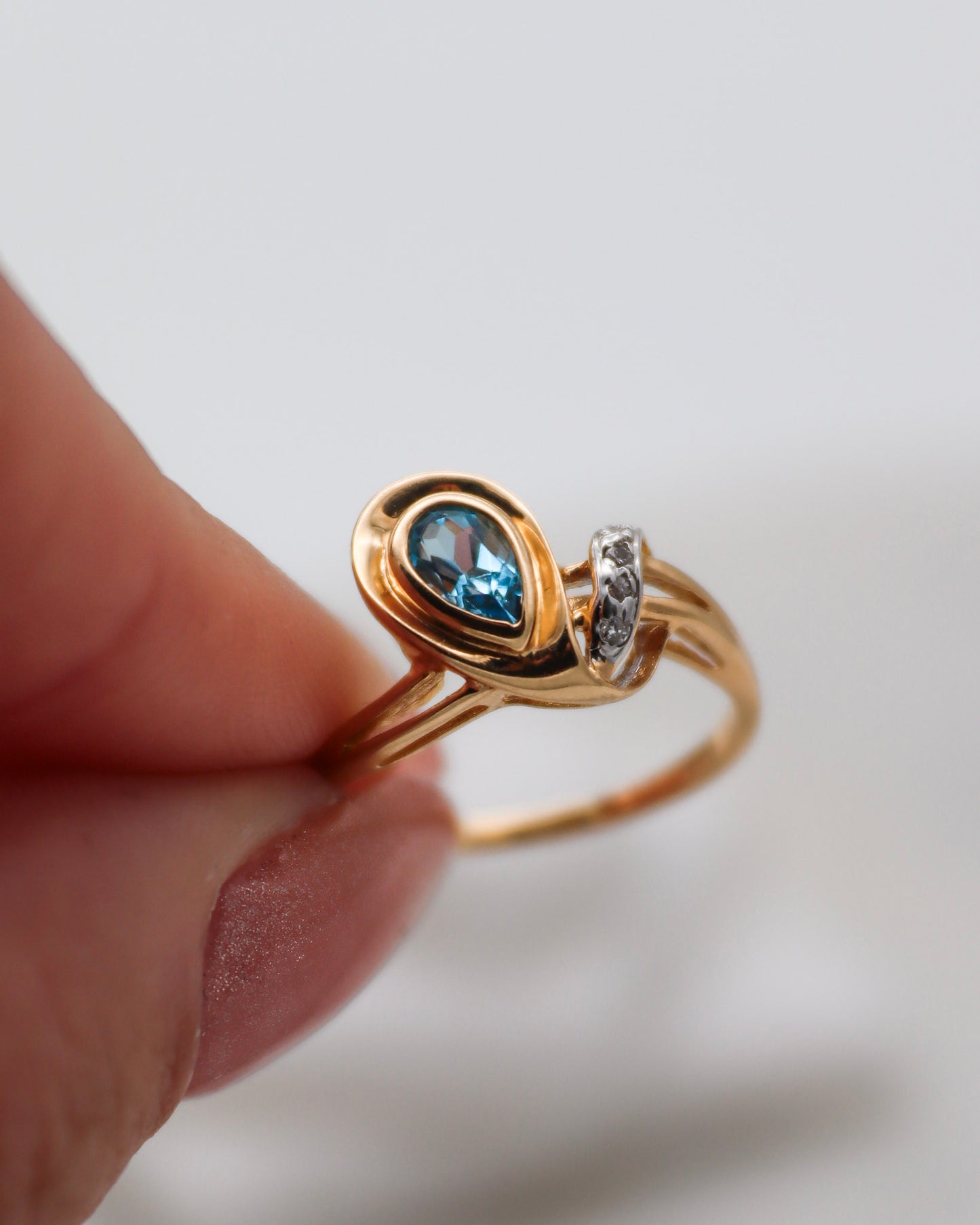 Eleganter Vintage-Ring Aretha mit birnenförmigem blauem Topas (0.20ct) und vier funkelnden Diamanten (0.03ct) in 585 Gelbgold. Erhältlich in München & Augsburg.